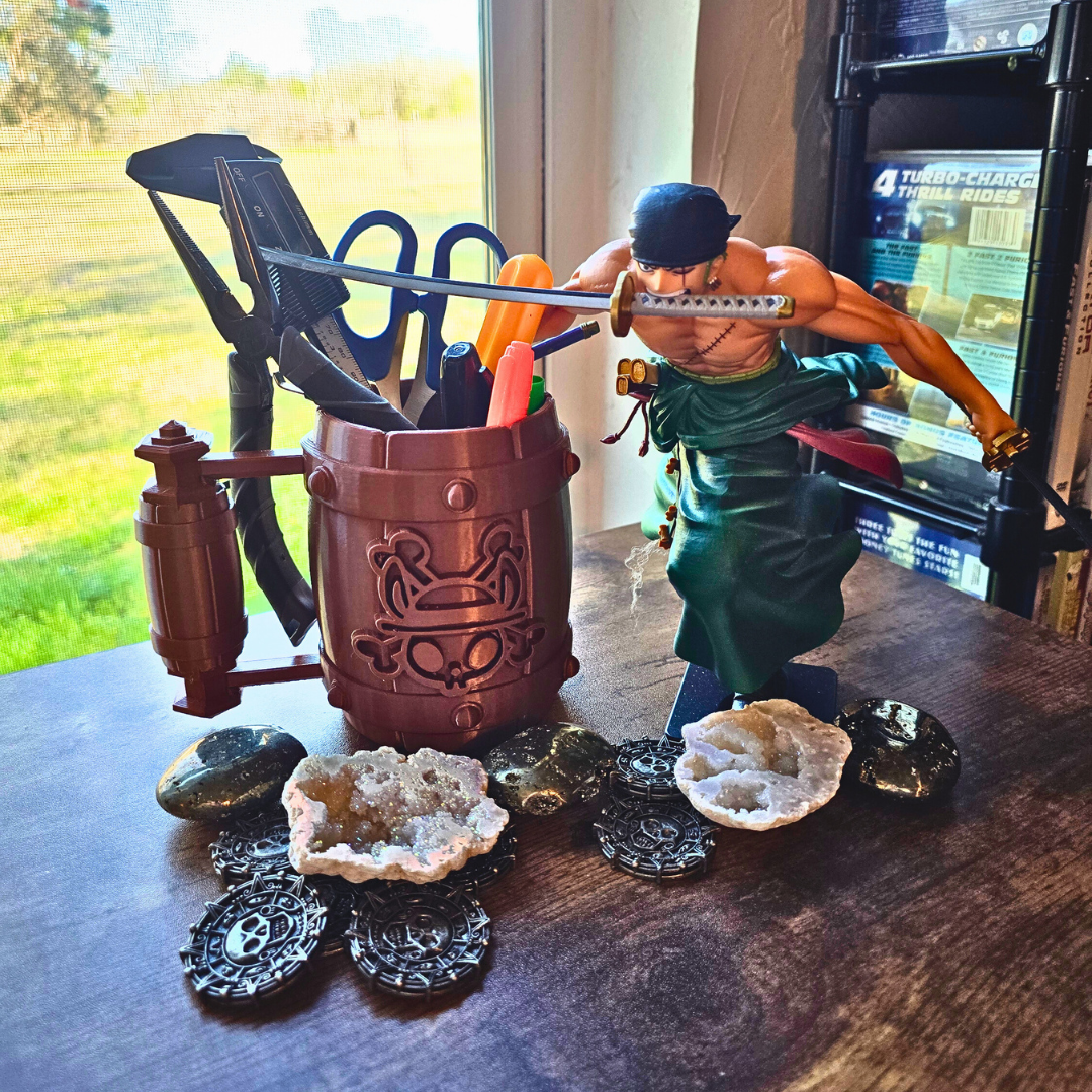 Desk setup with a decorative container holding tools in the tool cup in use, a figurine, and various small objects on a wooden surface.