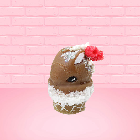 Cute kawaii bunny chocolate ice cream cone with glitter and red raspberries on top of the bunny near the swirl of whipped cream. This view is from the front at an angle.