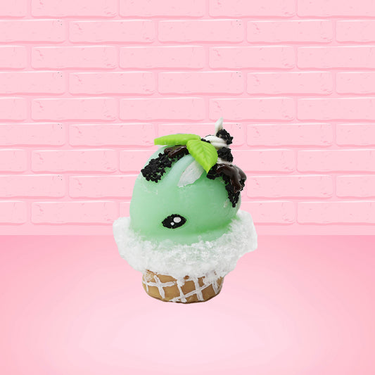 Cute kawaii bunny mint chocolate green ice cream cone with chocolate drizzle and sprinkles near the swirl of the whipped cream, with green mint leaves. The view is from the side.