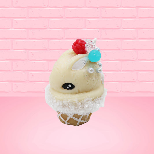 Cute kawaii bunny Vanilla Star Blast white ice cream cone with a blueberry, raspberry, and silver pearls near the swirl of whipped cream on the top of the bunny. This view is from the side.