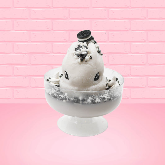 Cute kawaii bunny cookies and cream ice cream white scoop sundae with whipped cream swirls and black white crumbles in the dish. A black and white sandwhich cookie is on top of the resin bunny, sprinkled with black and white crumbles and a swirl of whipped cream. This view is from the front.