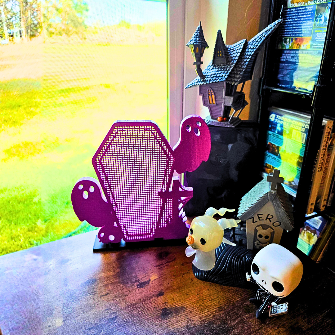Example display Ghost Coffin with Skull/Cross on desk, with a spooky house and ghost dog and skull figure character.