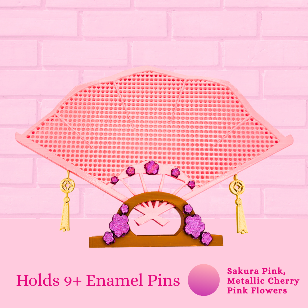 Sakura Pink Japanese fan close up with the words holds 9+ enamel pins.
