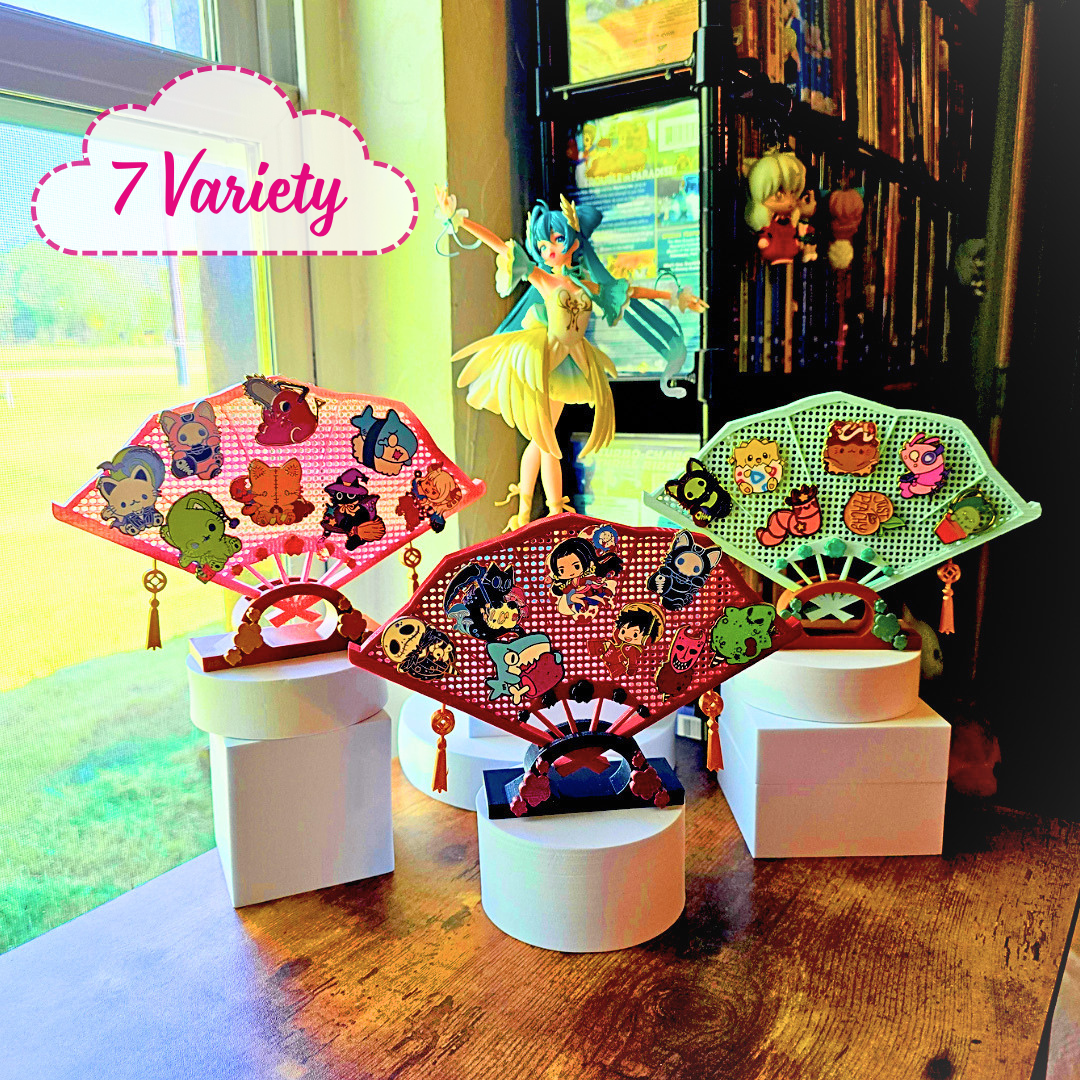 Different 3 colored fans with enamel pins on them, on top of a desk in a room with a blue haired anime girl figure and the words 7 Variety in a cloud, Example display holds 9+ Enamel Pins, Enamel Pins are not included.