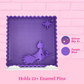A purple glitter mesh pin board with a witch riding a broom and star cutouts, shown against a pink brick wall background. Text on the image states it holds 22+ enamel pins and includes color swatches labeled Glitter Sky #1 and Purple Blue.