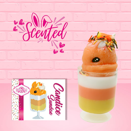 Cute kawaii bunny tall orange, white, and yellow ice cream sundae with yellow, brown, and orange sprinkles on top.  The top also has two pieces of candy corn near the whipped cream swirl. The front of the character card is shown, as well as the word scented.