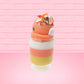 Cute kawaii bunny tall orange, white, and yellow ice cream sundae with yellow, brown, and orange sprinkles on top.  The top also has two pieces of candy corn near the whipped cream swirl. This view is from the back at an angle.