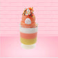 Cute kawaii bunny tall orange, white, and yellow ice cream sundae with yellow, brown, and orange sprinkles on top.  The top also has two pieces of candy corn near the whipped cream swirl. This view is from the back.