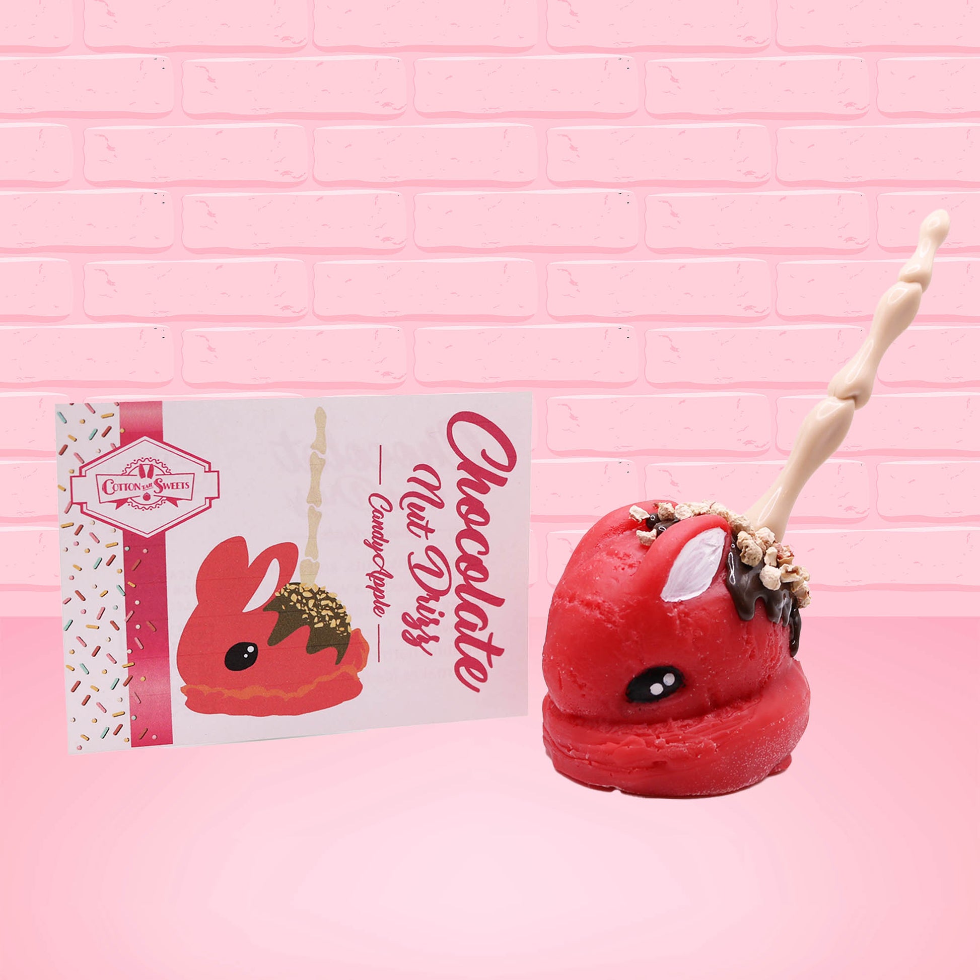 Cute kawaii red bunny with chocolate drizzle and nuts on the back of the bunny, with a finger stick in the back. 