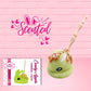 Cute kawaii green bunny with caramel drizzle and nuts with a boney finger stick.  The front of the character card and scented are shown.
