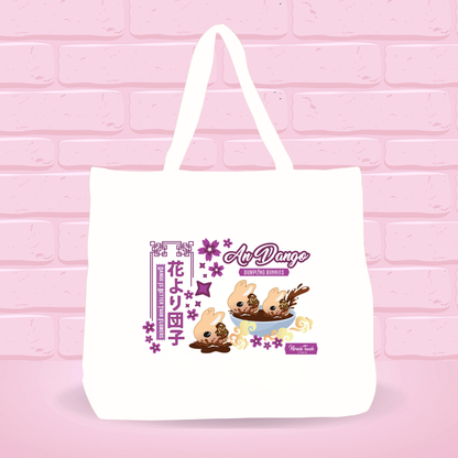 White tote bag with An Dango Dumplings and text on a pink brick wall background