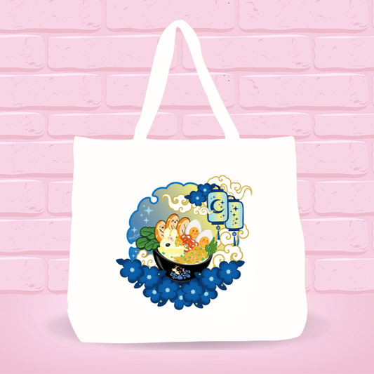 White tote bag with Moonlight Delight Ramen Bunny bowl nightly scenery design on a pink brick wall background.