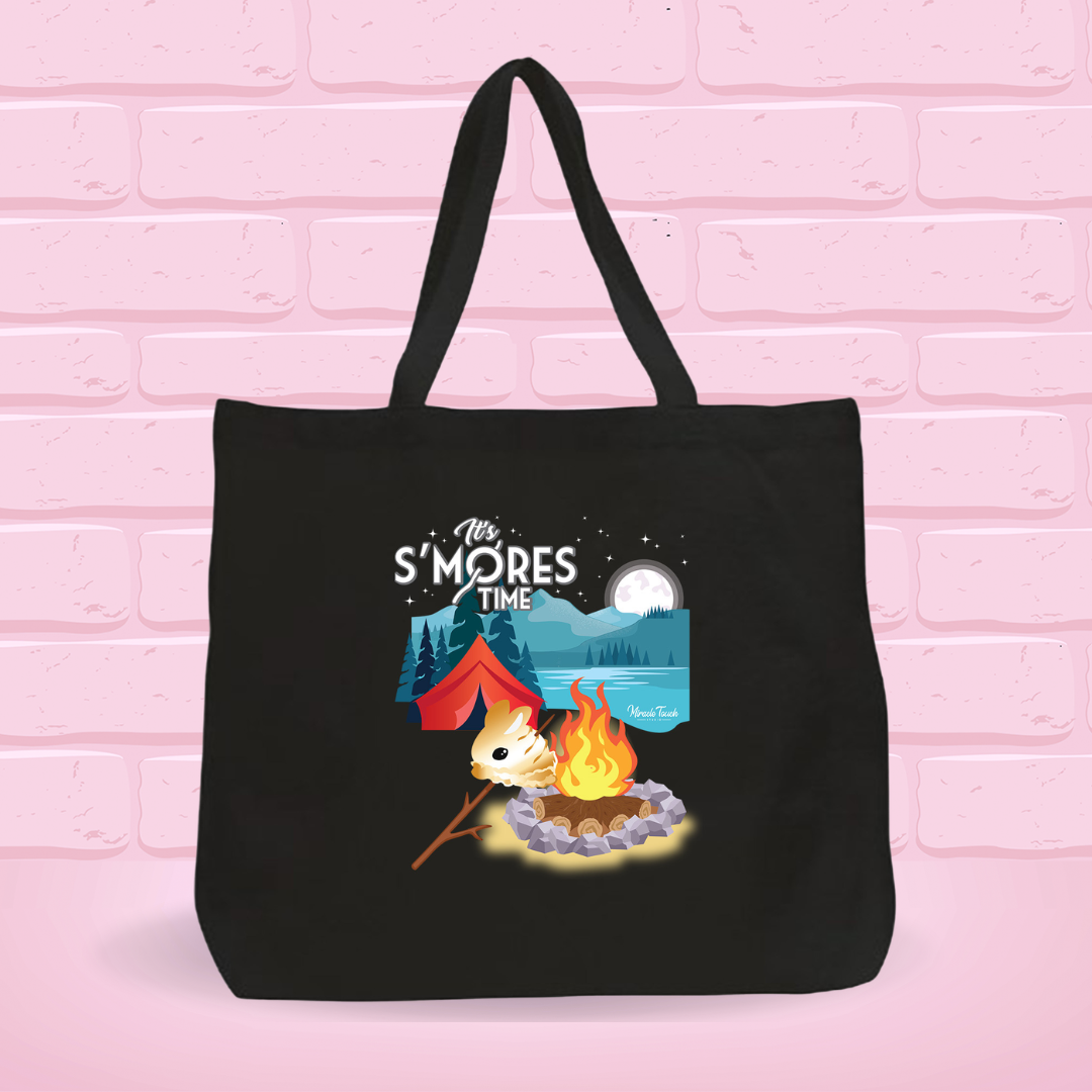 A black canvas tote bag with the S’more Bunny under a night starry camping scenery with a campfire Design on it.