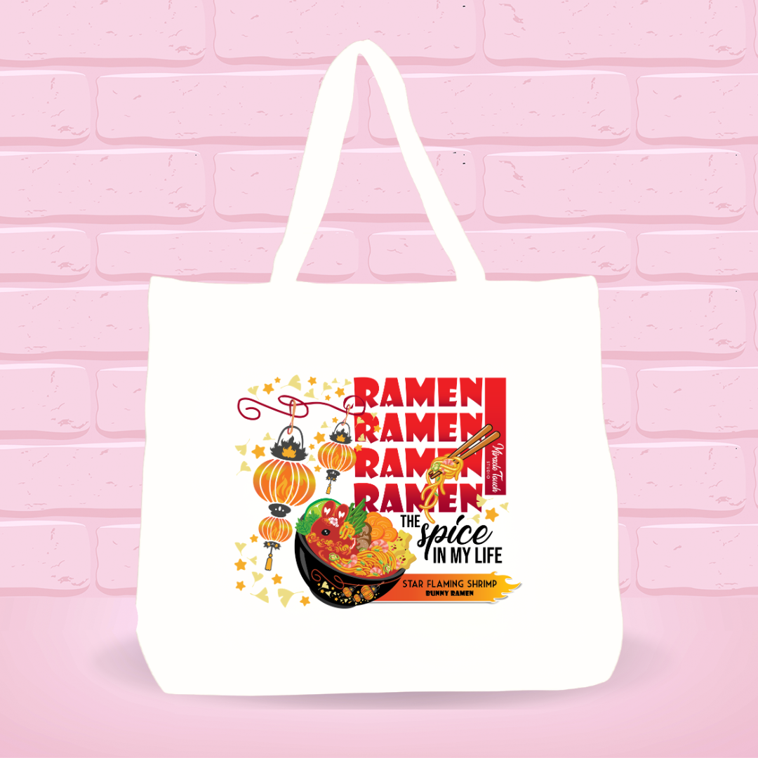 White tote bag with Star Flaming Shrimp Ramen Bunny bowl design,  text and quote on a pink brick wall background.