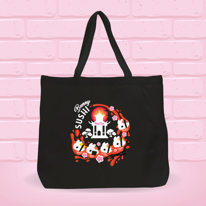 Black tote bag with a 'New Bunny Sushi set' design on a pink brick wall background