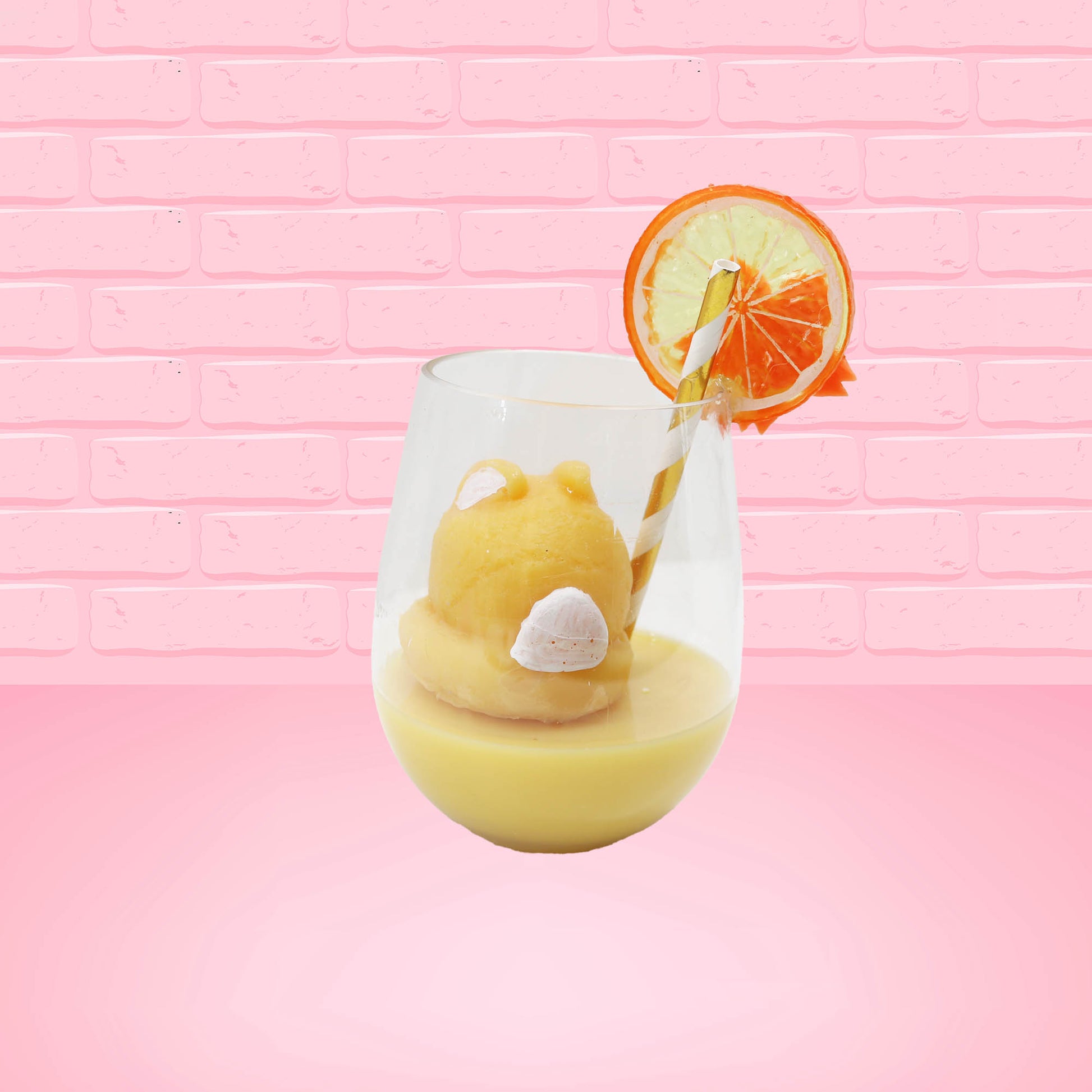 Cute kawaii bunny Screwdriver orange drink inside a glass with a gold white straw with an orange slice and orange flower on the rim of the glass. The view is from the back.