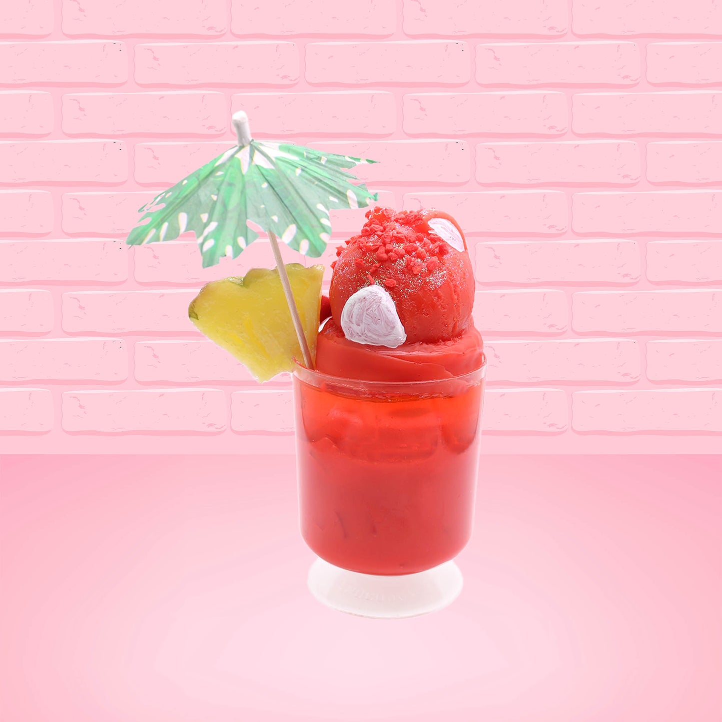 Cute kawaii bunny V12 red drink with red bits and white glitter on top of the bunny. A green palm tree umbrella with a pineapple slice and tomato slice on the rim of the drink on the side. This view is from the back.