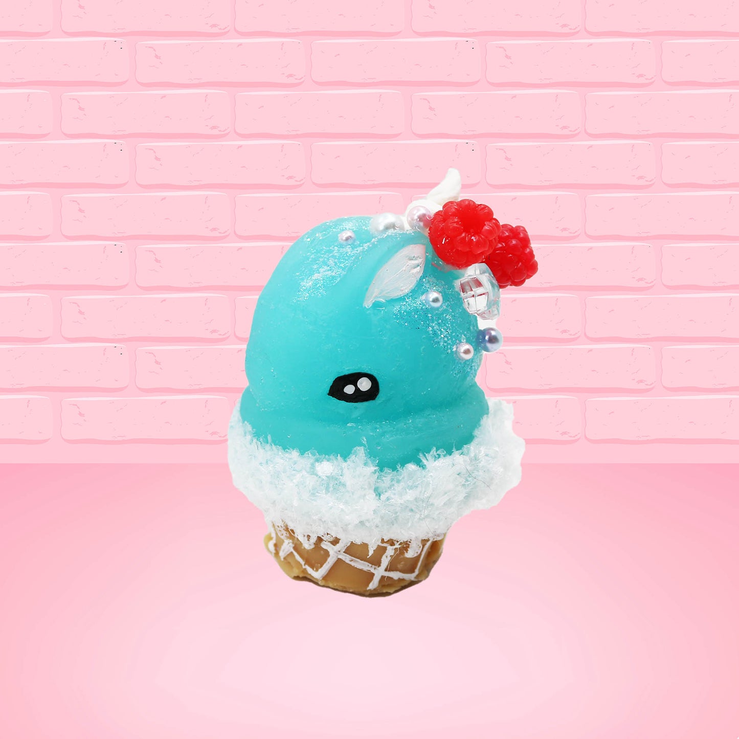 Cute bunny kawaii Blue Razz Star Blast blue ice cream with red raspberries, silver pearls and clear stars on the top of the bunny near the whipped cream swirl. This view is from the side.