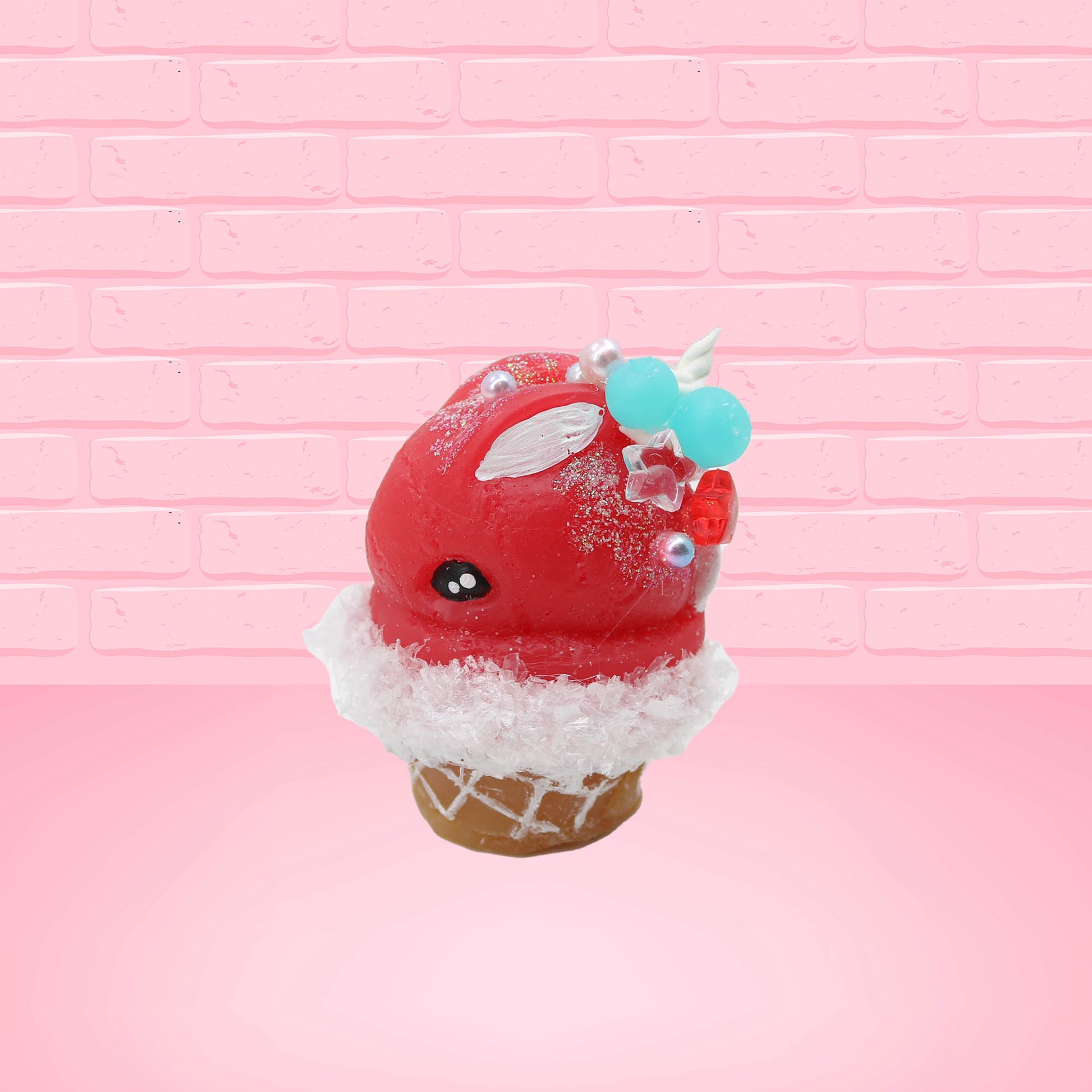 Cute kawaii bunny Cherry Star Blast red ice cream with light blue blueberries, silver pearls, and a clear star near the swirl of whipped cream on the top. This view is from the side.