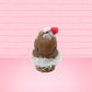 Cute kawaii bunny chocolate ice cream cone with glitter and red raspberries on top of the bunny near the swirl of whipped cream. This view is from the front.