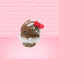 Cute kawaii bunny chocolate ice cream cone with glitter and red raspberries on top of the bunny near the swirl of whipped cream. This view is from the side.
