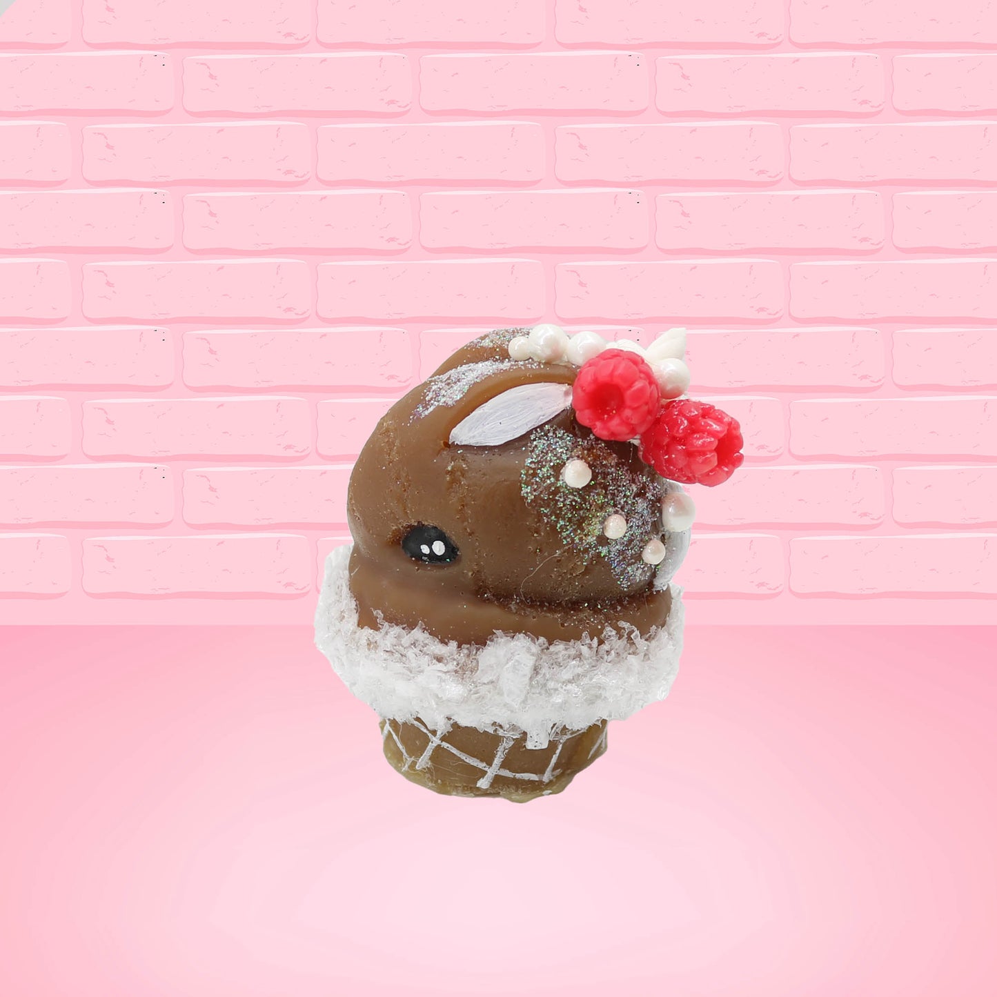 Cute kawaii bunny chocolate ice cream cone with glitter and red raspberries on top of the bunny near the swirl of whipped cream. This view is from the side.
