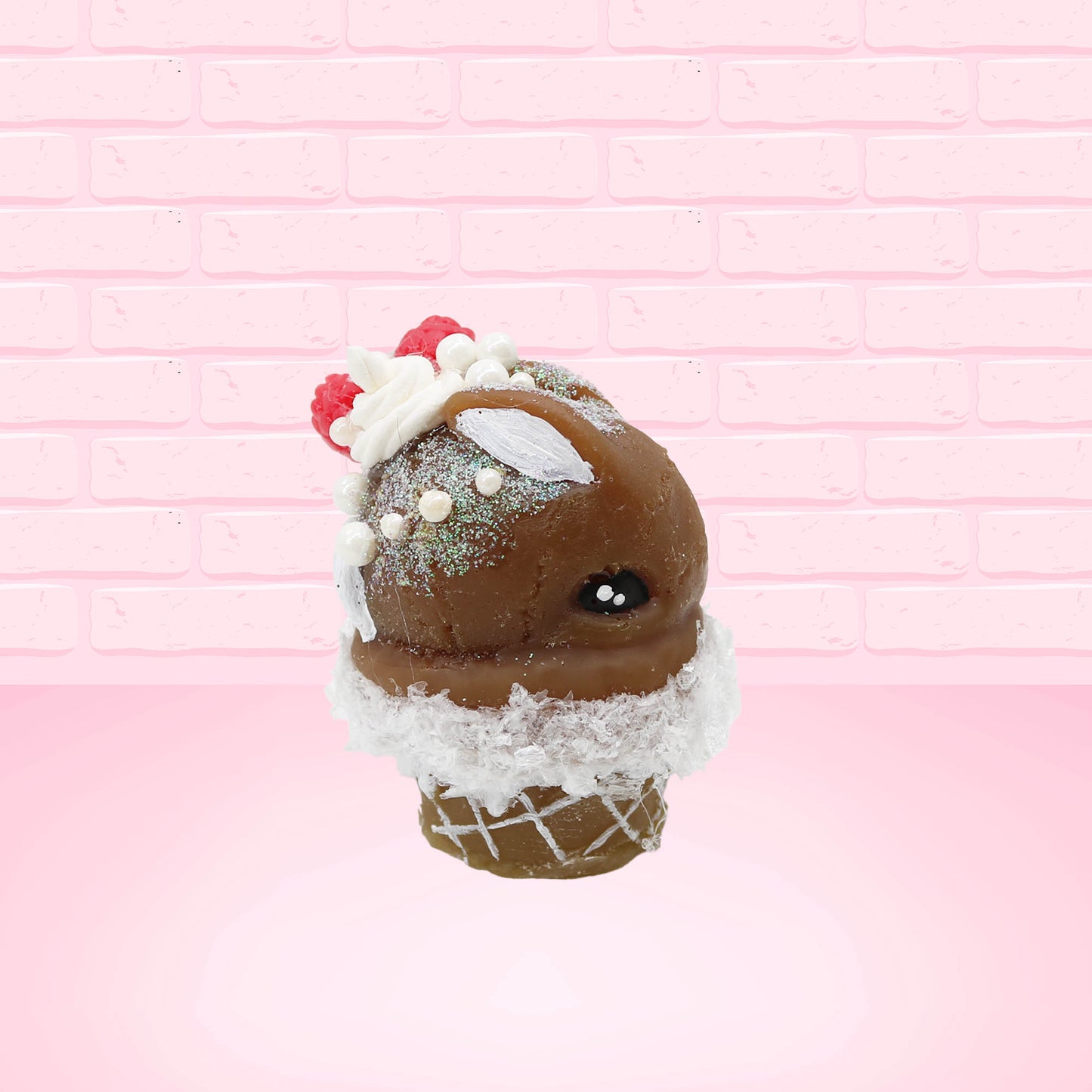 Cute kawaii bunny chocolate ice cream cone with glitter and red raspberries on top of the bunny near the swirl of whipped cream. This view is from the other side.