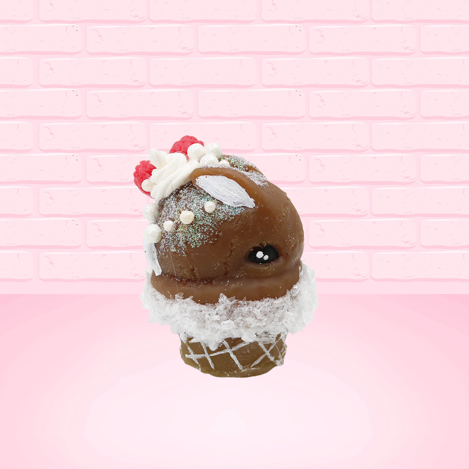Cute kawaii bunny chocolate ice cream cone with glitter and red raspberries on top of the bunny near the swirl of whipped cream. This view is from the other side.