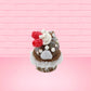 Cute kawaii bunny chocolate ice cream cone with glitter and red raspberries on top of the bunny near the swirl of whipped cream. This view is from the back.