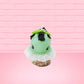 Cute kawaii bunny mint chocolate green ice cream cone with chocolate drizzle and sprinkles near the swirl of the whipped cream, with green mint leaves.  The view is from the front.