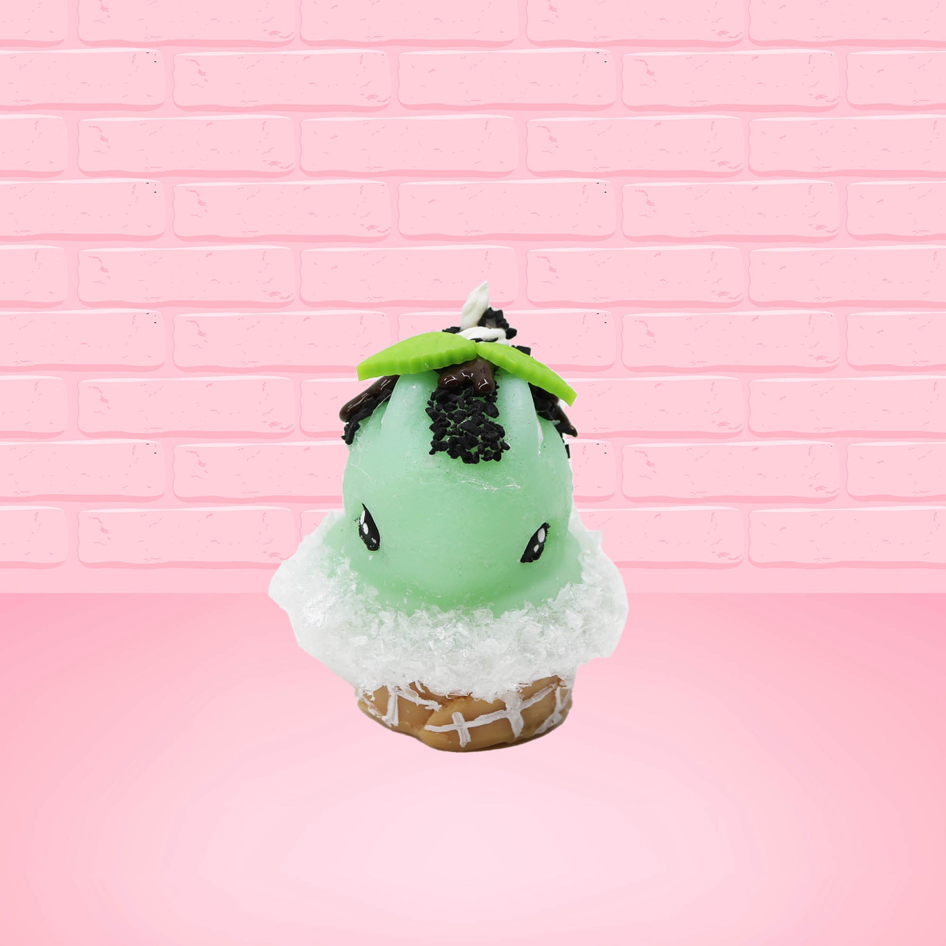 Cute kawaii bunny mint chocolate green ice cream cone with chocolate drizzle and sprinkles near the swirl of the whipped cream, with green mint leaves.  The view is from the front.