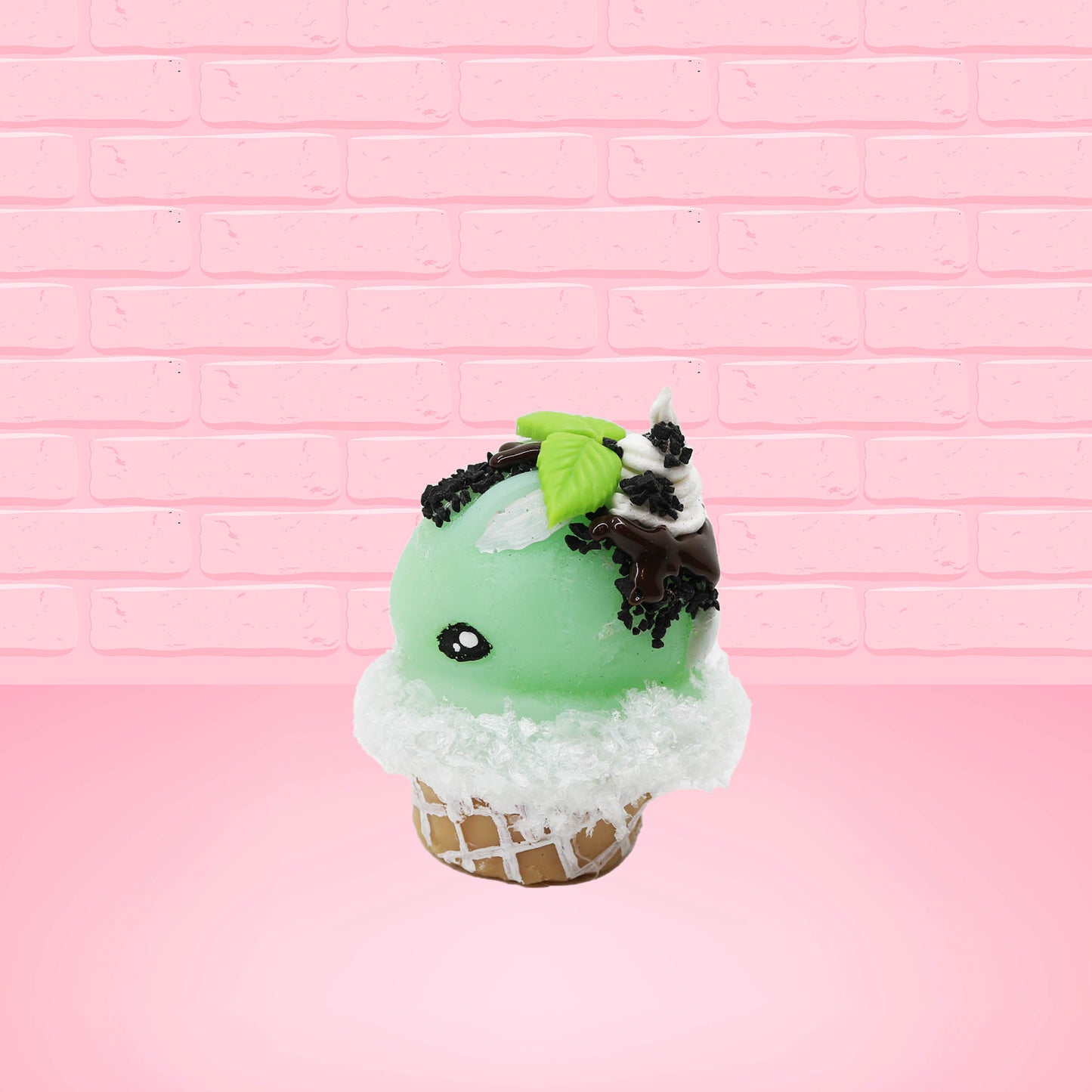 Cute kawaii bunny mint chocolate green ice cream cone with chocolate drizzle and sprinkles near the swirl of the whipped cream, with green mint leaves.  The view is from the other side.