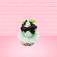 Cute kawaii bunny mint chocolate green ice cream cone with chocolate drizzle and sprinkles near the swirl of the whipped cream, with green mint leaves.  The view is from the back.