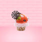 Cute kawaii bunny Monster Scoop orange ice cream cone with a blue eye in the center, green drizzle with chocolate bits, pumpkin sprinkles, a black spider and web near the top of the bunny next to swirl of the whipped cream. This view is from the side.