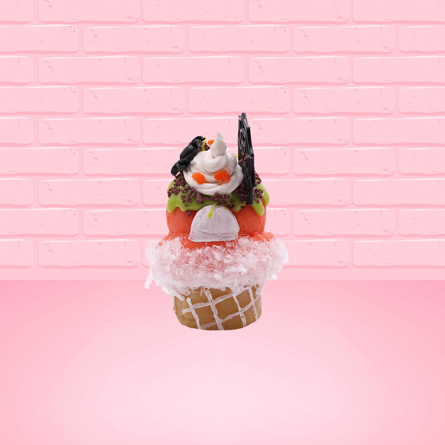 Cute kawaii bunny Monster Scoop orange ice cream cone with a blue eye in the center, green drizzle with chocolate bits, pumpkin sprinkles, a black spider and web near the top of the bunny next to swirl of the whipped cream. This view is from the back.