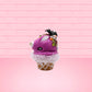Cute kawaii bunny Monster Scoop purple ice cream cone with a green eye in the center, green drizzle with chocolate bits, pumpkin and bat sprinkles, and a bat on the top of the bunny near the whipped cream swirl. This view is from the side.