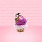 Cute kawaii bunny Monster Scoop purple ice cream cone with a green eye in the center, green drizzle with chocolate bits, pumpkin and bat sprinkles, and a bat on the top of the bunny near the whipped cream swirl. This view is from the other side.