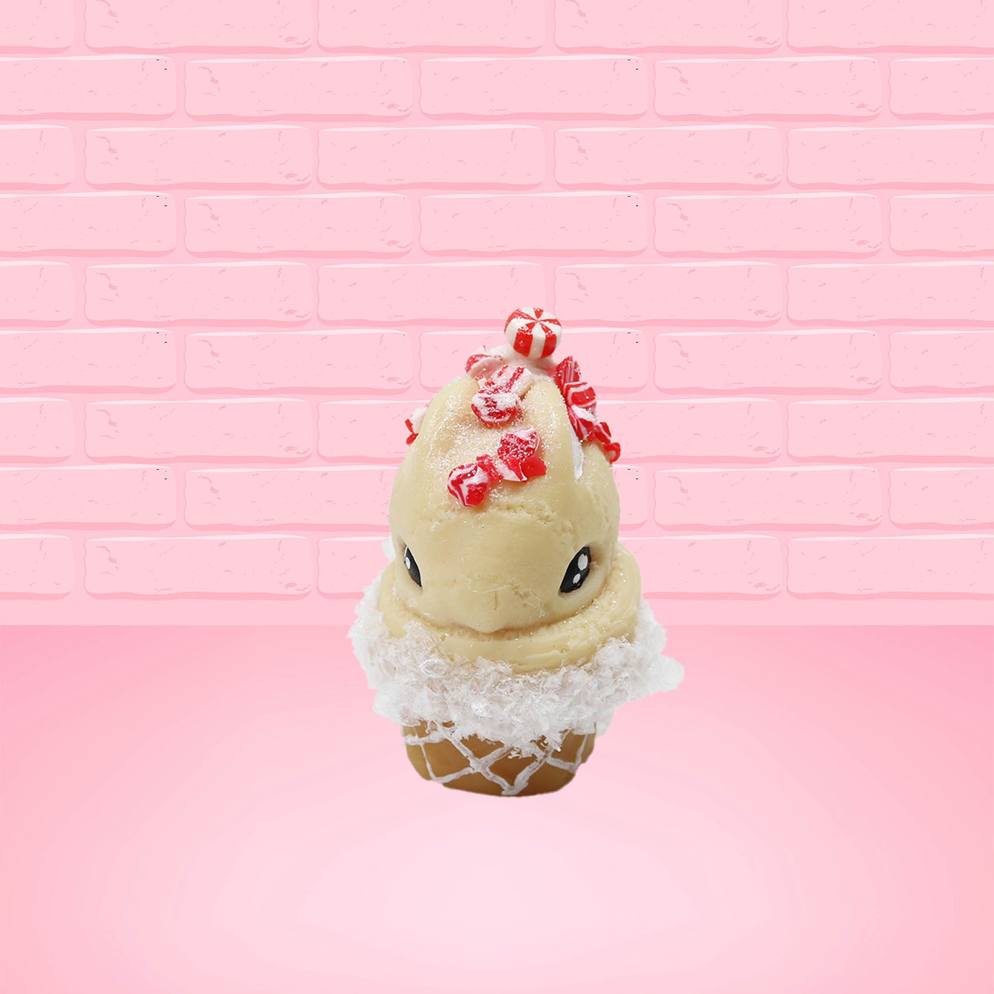 Cute kawaii bunny Peppermint Bark white ice cream with peppermint pieces and a peppermint candy on top of the bunny near the whipped cream swirl. This view is from the front.
