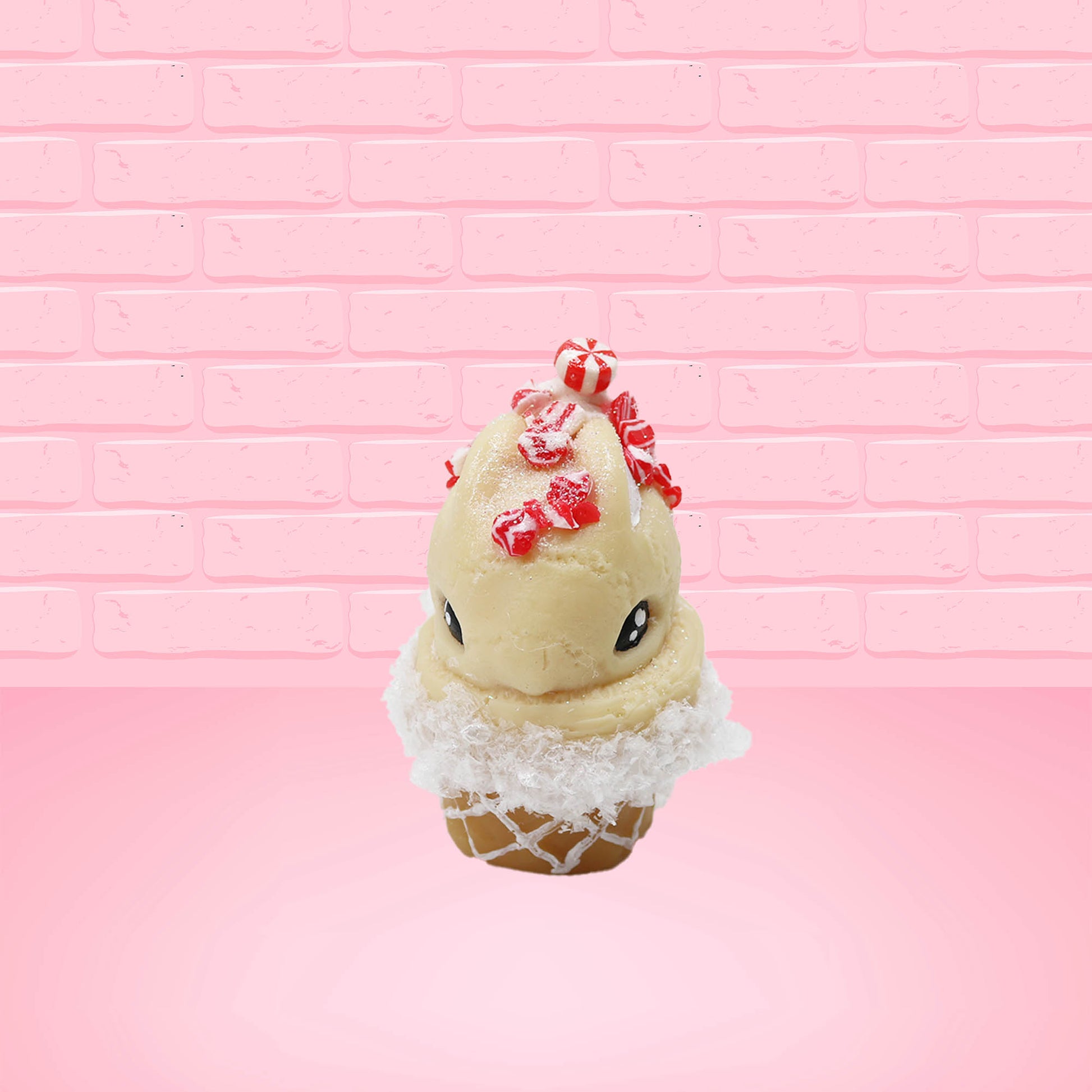 Cute kawaii bunny Peppermint Bark white ice cream with peppermint pieces and a peppermint candy on top of the bunny near the whipped cream swirl. This view is from the front.
