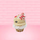 Cute kawaii bunny Peppermint Bark white ice cream with peppermint pieces and a peppermint candy on top of the bunny near the whipped cream swirl. This view is from the side.