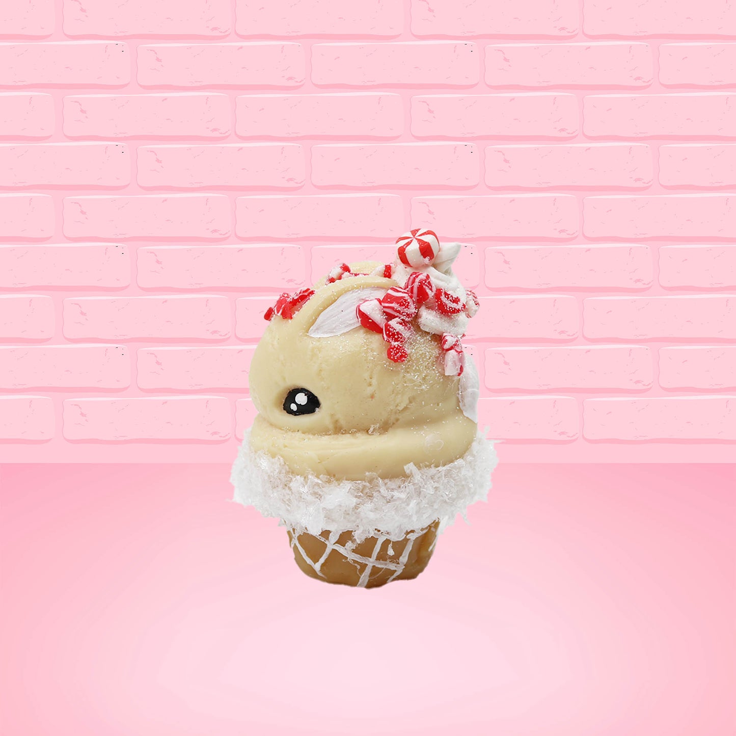 Cute kawaii bunny Peppermint Bark white ice cream with peppermint pieces and a peppermint candy on top of the bunny near the whipped cream swirl. This view is from the side.