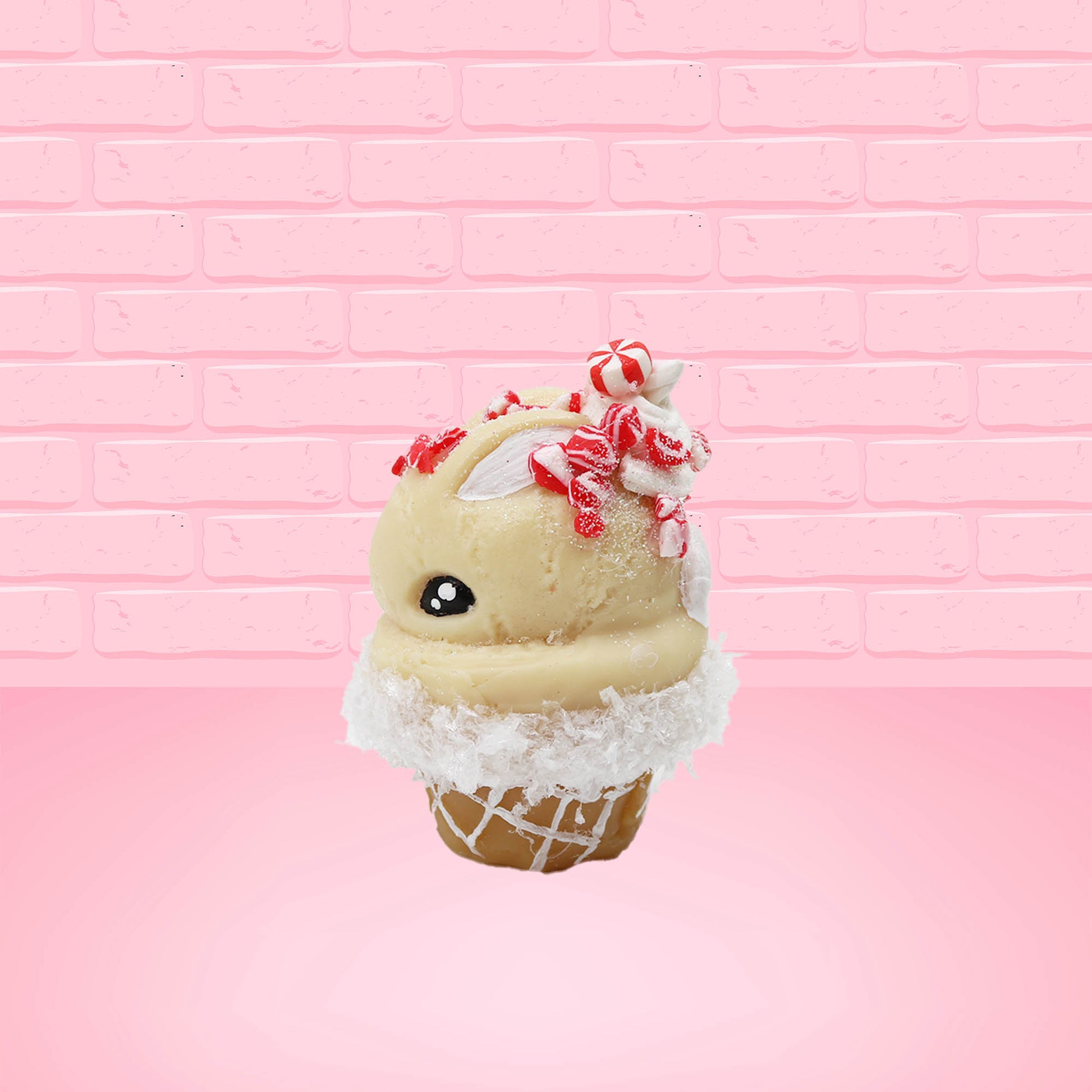 Cute kawaii bunny Peppermint Bark white ice cream with peppermint pieces and a peppermint candy on top of the bunny near the whipped cream swirl. This view is from the side.