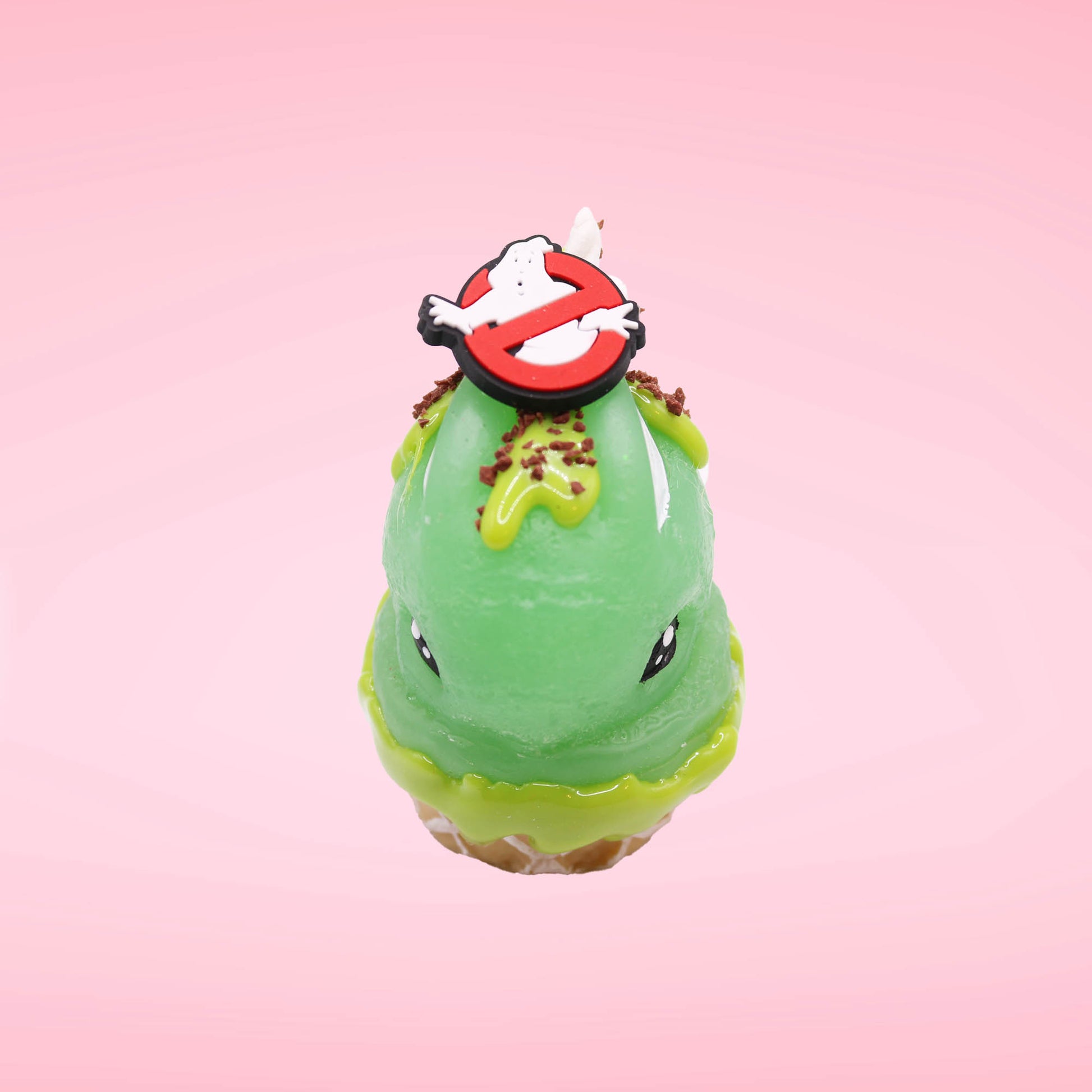Cute kawaii bunny Slimer Scoop green ice cream cone with green drizzle and brown bits, a ghost buster logo near the whipped cream swirl on top. This view is from the top side.