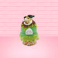 Cute kawaii bunny Slimer Scoop green ice cream cone with green drizzle and brown bits, a ghost buster logo near the whipped cream swirl on top. This view is from the back.