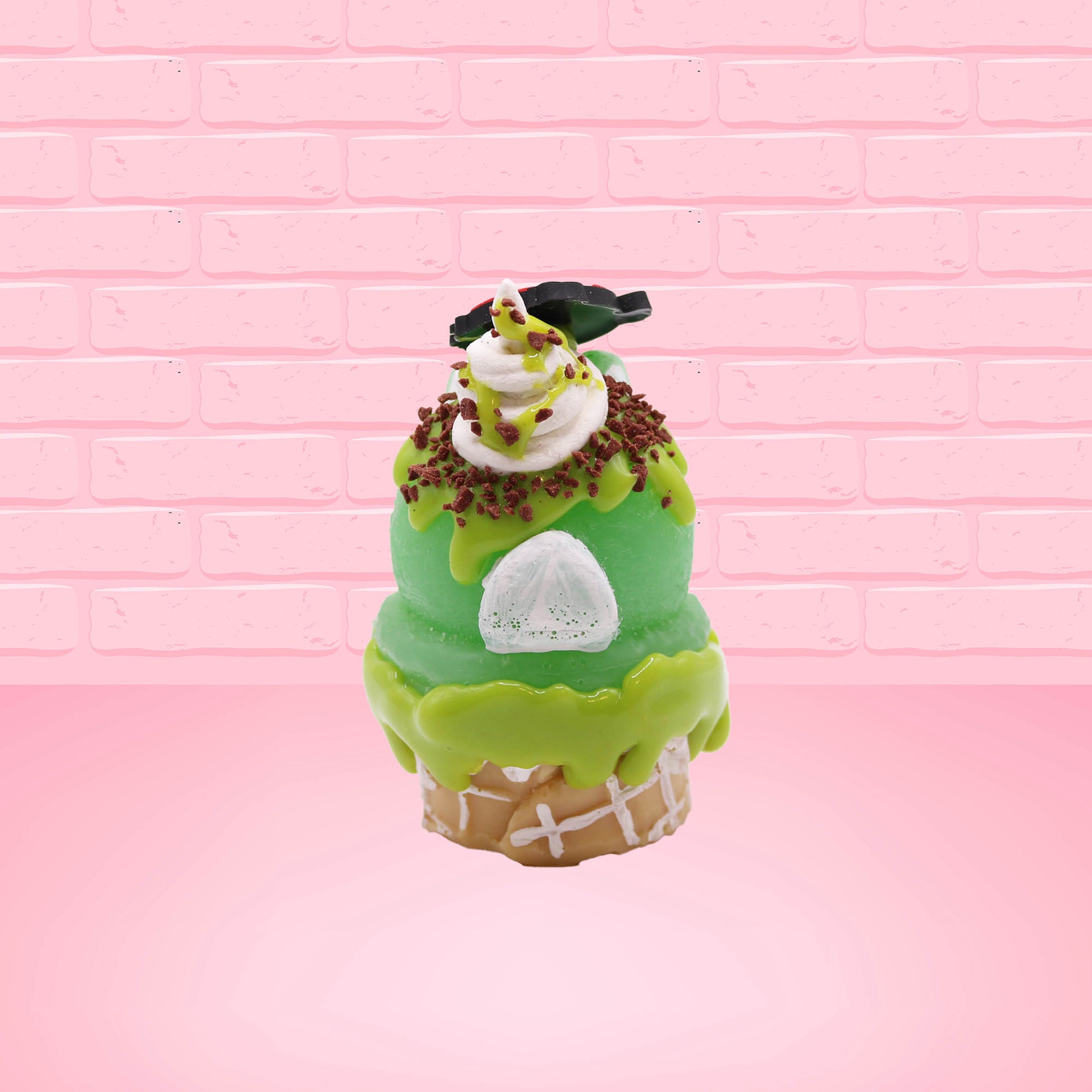 Cute kawaii bunny Slimer Scoop green ice cream cone with green drizzle and brown bits, a ghost buster logo near the whipped cream swirl on top. This view is from the back.