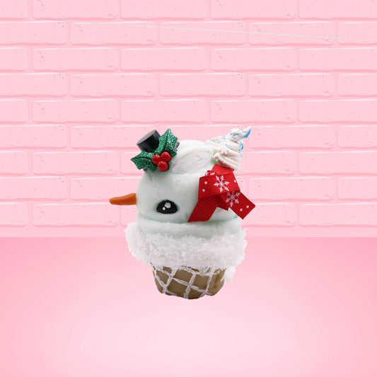 Cute kawaii bunny Snow Bunny light blue ice cream scoop with a carrot nose, red with silver snowflakes ribbon, a black top hat, and holly leaves with berries near the blue glittered whipped cream swirl on the top of the bunny. This view is from the side.