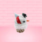Cute kawaii bunny Snow Bunny light blue ice cream scoop with a carrot nose, red with silver snowflakes ribbon, a black top hat, and holly leaves with berries near the blue glittered whipped cream swirl on the top of the bunny. This view is from the other side.