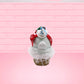 Cute kawaii bunny Snow Bunny light blue ice cream scoop with a carrot nose, red with silver snowflakes ribbon, a black top hat, and holly leaves with berries near the blue glittered whipped cream swirl on the top of the bunny. This view is from the back.