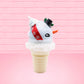Cute kawaii bunny Snow Bunny light blue ice cream scoop with a carrot nose, red with silver snowflakes ribbon, a black top hat, and holly leaves with berries near the blue glittered whipped cream swirl on the top of the bunny. This view is from the other side.