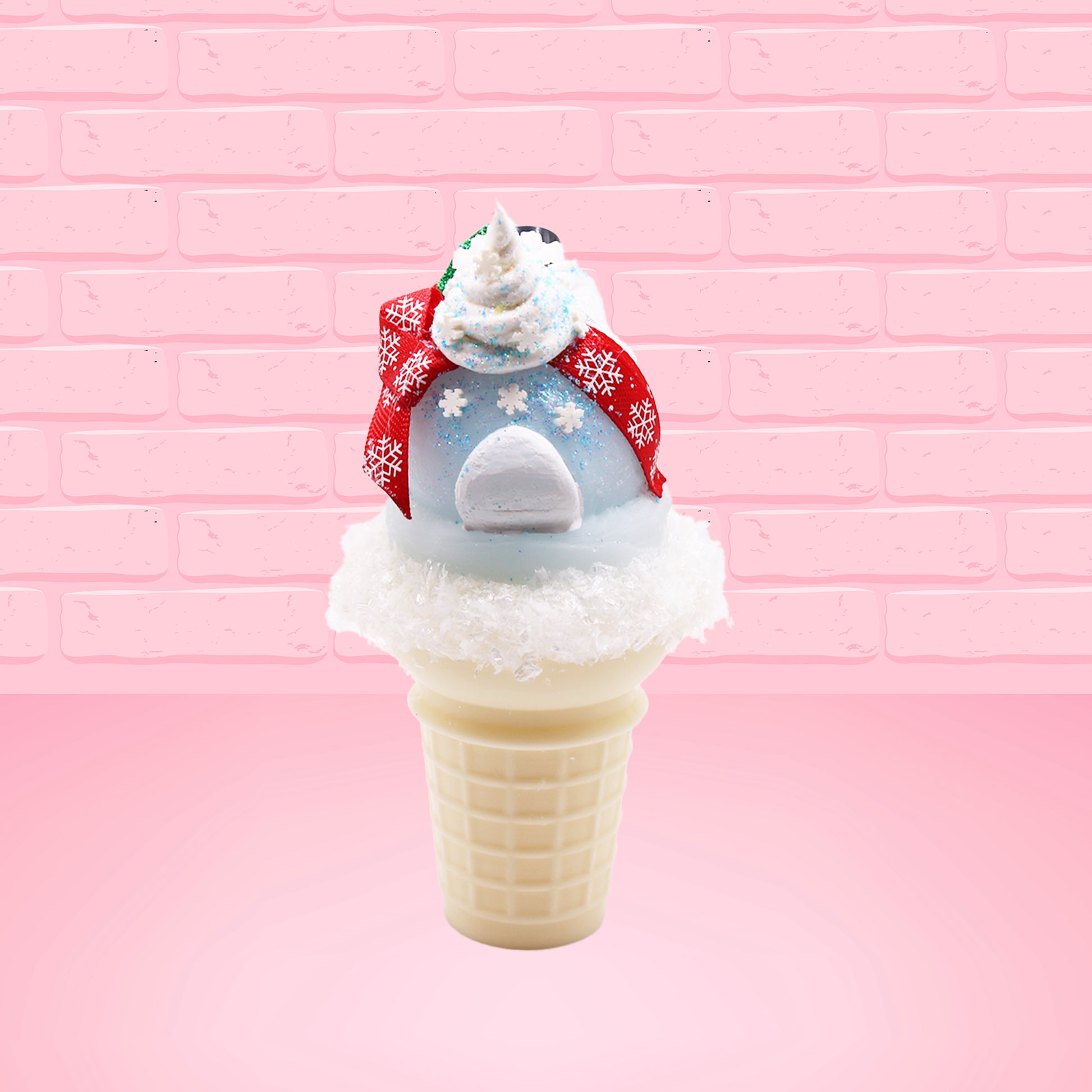 Cute kawaii bunny Snow Bunny light blue ice cream scoop with a carrot nose, red with silver snowflakes ribbon, a black top hat, and holly leaves with berries near the blue glittered whipped cream swirl on the top of the bunny. This view is from the back.